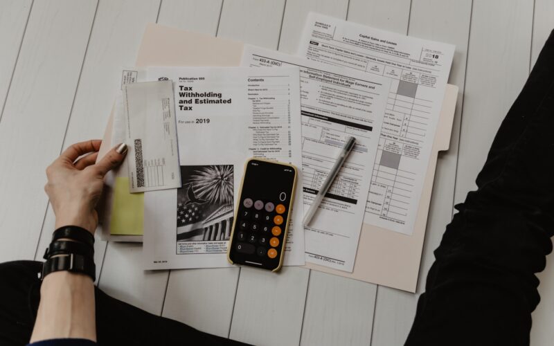 Side hustle financial records tracker with calculator and laptop